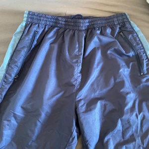 Träningsbyxor - Coola mörkblå puffiga träningsbyxor köpta secondhand! Har ljusblå ränder på sidan! Är märkta i storlek XL men passar nog M-XL! Frakt tillkommer efter vägning eller hämtas i Umeå!