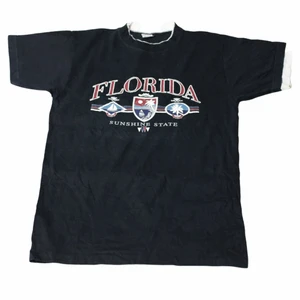 Florida - Vintage T-shirt - En riktigt cool svart tröja från Florida som har ett stort detaljerat tryck över bröstet och ett fint svart tyg. Har även vita detaljer vid halsen och ärmarna. Den har riktigt grova nittiotal vibbar. 
