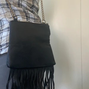 Handväska  - Axelremsväska med fransar nertill. Inköpt från Vero Moda för flera år sedan. Använd men i bra skick! 