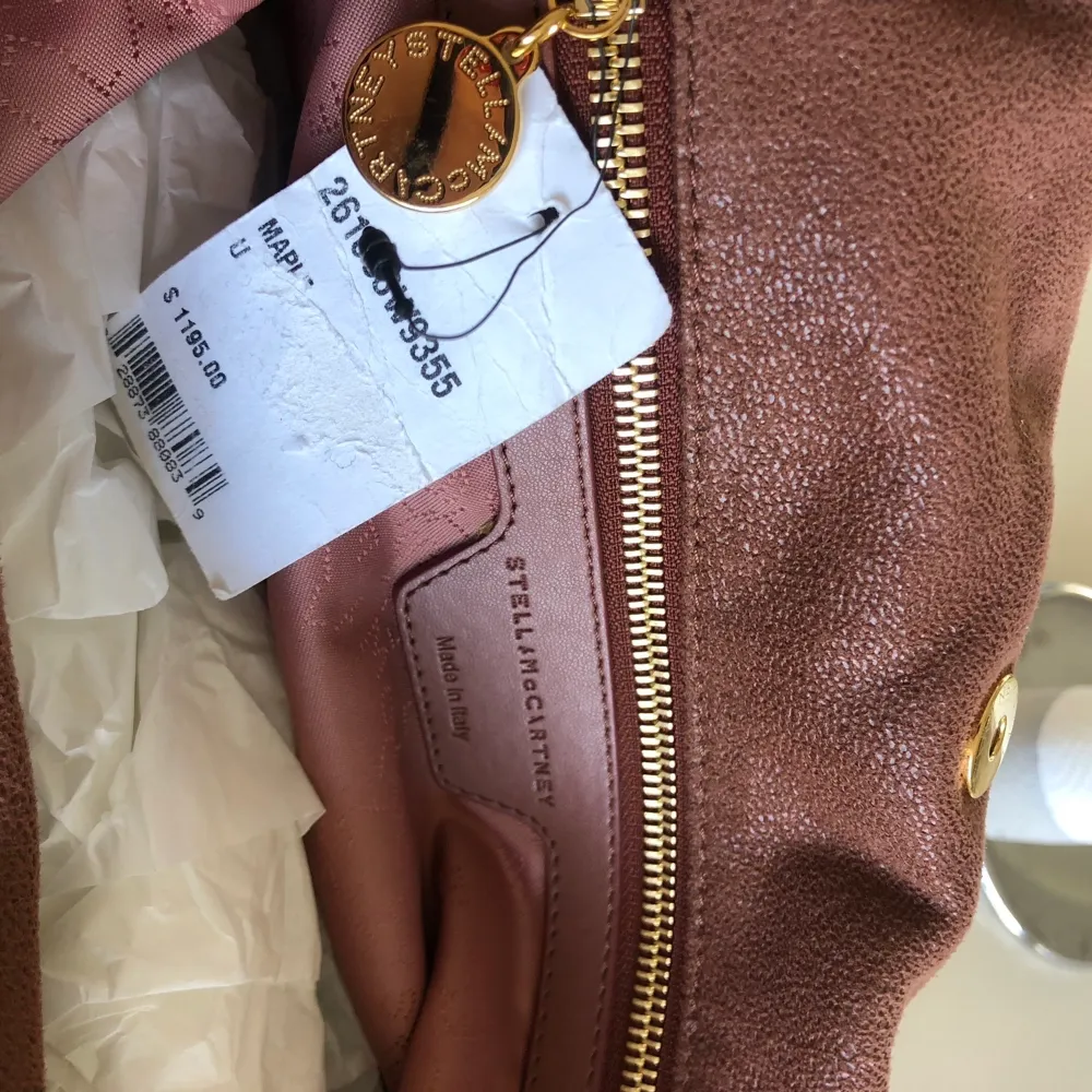 Helt oanvänd Stella McCartney väska köpt i USA för 1195 USD. Den är i färgen Maple (brun) med guldkedja. Modellen heter Falabella Shaggy Deer tote. Kommer med dustbag🤍Inga byten eller prutningar!. Väskor.