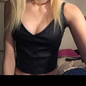 Svart topp storlek s  -  Säljer denna svarta topp då den inte har kommit till användning. Kostar 100 med frakt. Den är i material av fejk skinn, den är i topp skick 