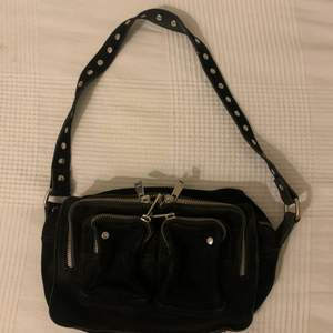 En svart klassisk Nunoo väska i storlek Medium. Den har ett kort band så att väskan kan hängas över axeln. Säljer då jag inte får användning av den längre men den är i ett bra skick!