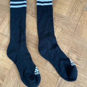 Adidas strumpor - Ett par svarta långstrumpor med vita ränder från adidas