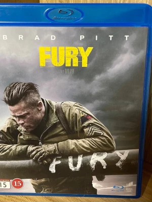 Fury Blu-ray film - Blu-ray-utgåva av filmen Fury med Brad Pitt i huvudrollen. Omslaget är blått och motivet visar en soldat i militärjacka mot en dramatisk himmel. Innehåller exklusivt extramaterial och är masterad i 4K för bästa bildkvalitet.
