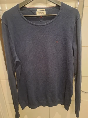 Blå långärmad tröja Hilfiger Denim - Mörkblå långärmad tröja från Hilfiger Denim med rund halsringning och liten broderad logga på bröstet. Tröjan har en enkel och stilren design, perfekt för dig som gillar klassiska plagg. Materialet känns mjukt och bekvämt.