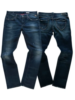 Mörkblå jeans från Replay - Snygga mörkblå jeans från Replay med slitna detaljer och kontrastsömmar. Klassisk femficksmodell med raka ben och låg midja. Jeansen har coola slitningar framtill och bakfickor med dekorativa sömmar. Perfekta för en avslappnad streetstil. 