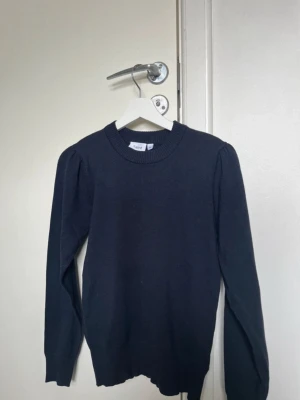 Mörkblå stickad tröja  - Mörkblå stickad tröja från Saint Tropez med rund halsringning och puffade axlar. Tröjan har långa ärmar och ribbade muddar vid hals, ärmslut och nederkant. Aldrig använd❣️