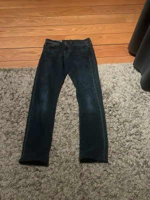 Levi’s 502 - Snygga mörkblå jeans från Levi's med klassisk femficksmodell och raka ben. Jeansen har diskreta slitningar och en liten röd Levi's-tag på bakfickan. Tillverkade i slitstark denim som ger en tidlös look. Model 502                                                     W28 och från början L32 men är uppsydda till L30