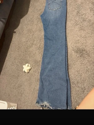 Blå bootcut jeans med slitna detaljer - Lite slitna där nere vid beena För dome lite långa , passar bäst För 36 även ifall dene 38 går också för 38 