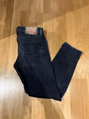 Mörkblå jeans från Diesel Industry - Snygga mörkblå jeans från Diesel Industry med klassisk femficksdesign och raka ben. Jeansen har en diskret tvättad look och patch med logga bak i midjan. Perfekta för dig som gillar stilrena och tidlösa jeans.