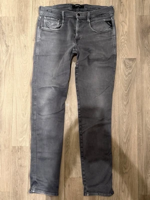 Replay Anbass Hyperflex Jeans Grå W33/L32 - Slim Fit - Replay Anbass Hyperflex grå jeans i stretchig Hyperflex denim med slim fit passform som sitter snyggt och bekvämt och funkar till allt, storlek W33/L32, midja 42 cm, ytterbenslängd 107 cm, benöppning 15,5 cm, modellen är 185cm & väger 65kg, i fint skick.