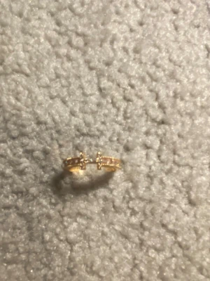 Guldfärgad ring med pärldetaljer - Snygg guldfärgad ring med små pärldetaljer längs hela ringen. Ringen har en öppen design vilket gör den justerbar och unik. Perfekt för dig som gillar trendiga accessoarer med det lilla extra.
