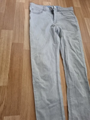 Fyra par jeans - Säljer fyra par jeans i . Ena paret är ljusgrått och det andra är mörkgrått med klassisk femficksdesign och smal passform. Perfekta för dig som gillar en stilren och enkel look. Materialet är denim.