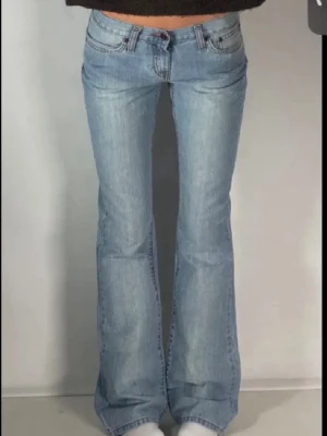 Ljusblå bootcut jeans med låg midja - Säljer ett par ljusblå bootcut jeans med låg midja och klassiska fem fickor. Jeansen har utsvängda ben och är tillverkade i denim med en snygg tvätt. Perfekta för dig som gillar retrostil och vill ha ett par trendiga jeans. Lånade bilder. Säljer för de inte riktigt passade mig💕