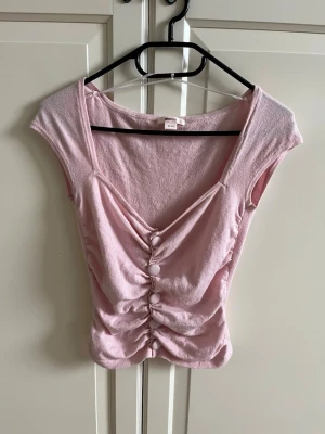 Rosa topp - Säljer en superfin ljusrosa topp med knappar från Gina tricot. Toppen är väldigt mjuk och stretchig i materialet. Perfekt till vardags eller fest. Endast använd en gång och därefter tvättad, alltså är den fortfarande i nyskick. Storlek xs. Man får med en extraknapp🩷