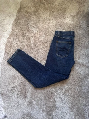 Nudie jeans - Tjena, säljer ett par blåa nudie jeans i modellen gritty Jackson. Jeansen är endast använda några fåtal gånger så skicket är så gott som nytt👍. Storleken är 28/32 men har töjts ut lite i midjan så sitter snarare som 29/32. Midja: 38 cm. Ytterbenslängd: 101 cm. Priser år heller inte hugget i sten. Skriv angående frågor och funderingar👌