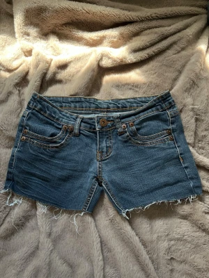 Blå lågmidjade jeansshorts  - Säljer ett par klassiska blå lågmidjade jeansshorts  i storlek S