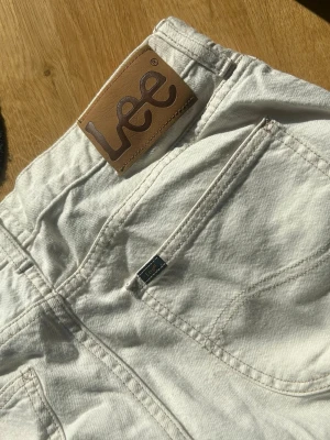 Vita jeans från Lee - Snygga vita jeans från Lee med klassisk femficksdesign och dragkedjegylf. Jeansen har en stilren look med Lee-logga på bakfickan och läderpatch i midjan. Tillverkade i bomull för en bekväm känsla och passar perfekt till många olika outfits.