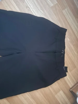 Svarta kostymbyxor från ONLY - Säljer ett par svarta kostymbyxor från ONLY med klassisk rak passform och hällor för skärp. Byxorna har en stilren look 