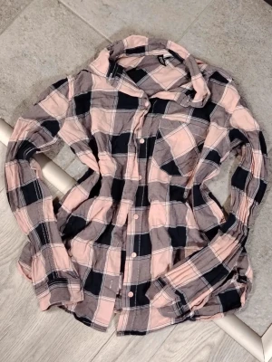 Rutig rosa och svart skjorta💓  - Kaunis flanelli paita😍 Käytetty, mutta yhä erinomaisessa kunnossa🫶🏻 Varanapit tallella. 100% puuvillaa💎 XS-S.