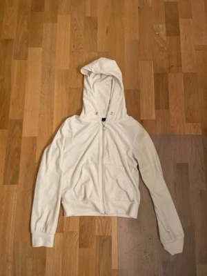 Vit zip hoodie från Gina Tricot XS - Säljer en vit hoodie från Gina Tricot i storlek XS. Hoodien har dragkedja framtill med en rund metallring som dragare, två fickor och huva med metallöljetter. Tillverkad i mjukt tyg som känns skönt mot huden. Perfekt för en chill och avslappnad stil.