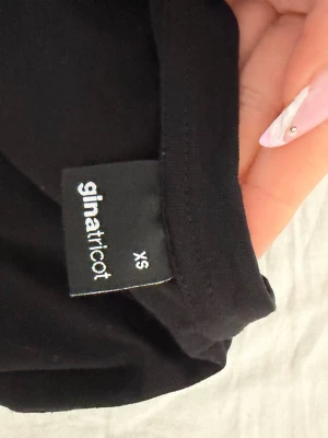 Svart basic t-shirt Gina Tricot - En svart basic t-shirt från Gina Tricot i storlek XS. T-shirten har rund halsringning och korta ärmar. Pris går att diskutera och jag kan skicka de snabbt! 💕