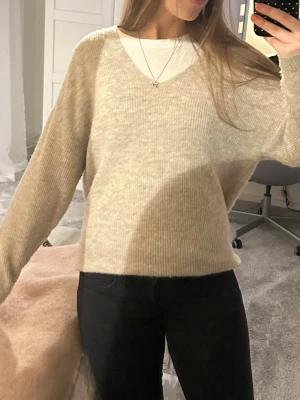 Beige stickad tröja med v-ringning - Supermysig beige stickad tröja med v-ringad hals och lång ärm, inga skador!!❣️❣️❣️