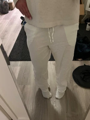 Vita linnebyxor med dragsko - Säljer ett par vita linnebyxor med avslappnad passform och dragsko i midjan. Byxorna har raka ben och sidofickor, perfekta för en chill och stilren look. Materialet är lätt och luftigt linne, vilket gör dem sköna att bära. Perfekta till sommaren💝💝