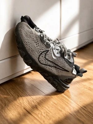 Grå Nike React Vision sneakers - Snygga grå Nike React Vision sneakers med svart sula och svart swoosh på sidan. Ovandelen är i meshmaterial med vita och svarta detaljer, samt grå skosnören. Skon har en chunky design och bekväm dämpning, perfekt för en streetwear-look.