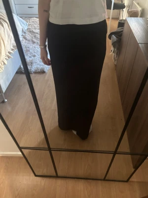 Svart kostymkjol - Säljer en svart kostymkjol från JJXX (nelly) i enkel och stilren design. Kjolen har rak passform och har en svart slit framtill! Aldrig använd och har prislapp kvar🖤