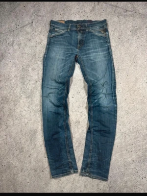 Blå jeans från Replay Jeans - Säljer ett par klassiska blå jeans från Replay Jeans med snygg slitning och raka ben. Jeansen är perfekt för en avslappnad och trendig look.