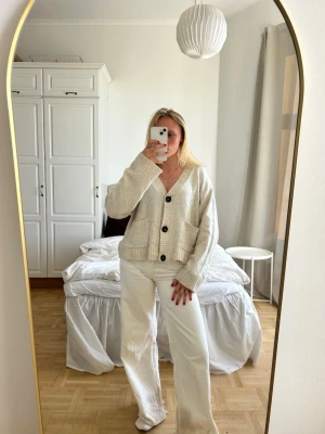 Beige kofta med stora knappar💖💖 - Mysig beige kofta med v-ringning och stora svarta knappar framtill. Koftan har två rejäla fickor och en avslappnad, boxig passform. Perfekt att slänga över en t-shirt för en chill look. Stickad i mjukt material och har långa ärmar.