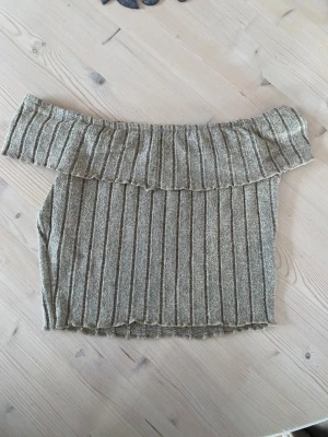  offshoulder topp från SHEIN - Säljer ribbad offshoulder topp från SHEI. Toppen har en snygg croppad passform och bred volangkant upptill. Köparen står för frakt.