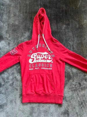 Superdry hoodie - Riktigt fet röd ”limited edition” hoodie från Superdry. Tröjan sitter fint och är i bra skick. Hör av dig vid frågor! Billigaste frakten!