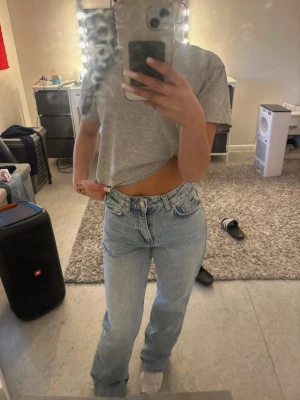 Ljusblå raka jeans från Ginatricot - Säljer ett par ljusblå raka jeans från Levi's med klassisk femficksdesign och hög midja. Jeansen har en avslappnad passform och är tillverkade i denim. Perfekta för en chill och trendig look.