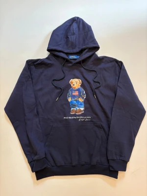Ralph Lauren hoodie XL - Marinblå Ralph Lauren polo bear hoodie // 10/10 skick aldrig använd // storlek XL // längd 70cm axelbredd 54cm armlängd 64cm // skriv vid minsta fråga eller fundering🤝