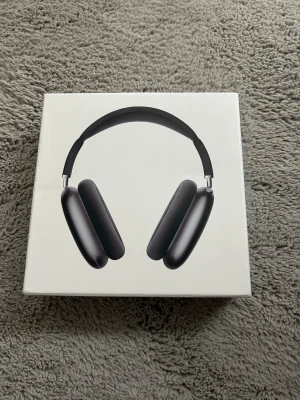 Apple AirPods Max Svart - Snygga Apple AirPods Max i svart med stilren design och mjuka öronkuddar. Over-ear-modell med metallbåge och meshband för extra komfort. Perfekta för musik, gaming eller film. Levereras i originalförpackning med smart skyddsfodral.