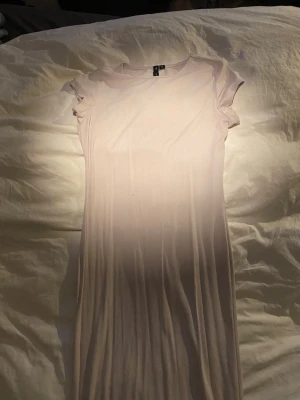 Ljus ribbad kortklänning H&M - Säljer en ljus, ribbad lång klänning. Klänningen har rund halsringning och korta ärmar. Enkel och stilren design som passar perfekt till sommaren. Materialet är mjukt och stretchigt, vilket gör den bekväm att bära. Jag på 177cm lång räcker ner till mitten av smalbenet.