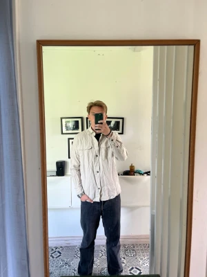 Linneovershirt Beige  - Säljer en stilren beige overshirt med två stora bröstfickor och knäppning framtill. Overshirten har en avslappnad passform och är tillverkad i ett lätt material som passar perfekt för lager-på-lager. Enkel att matcha med jeans eller chinos. Storlek S från Dressman