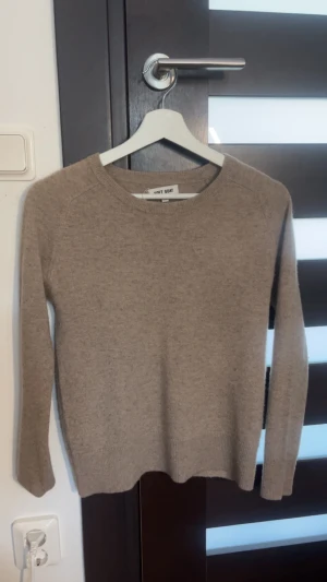 Beige stickad tröja Soft Goat XS - Säljer en beige/brun stickad tröja från Soft Goat i storlek XS, tajt modell. Tröjan har rund halsringning och långa ärmar, tillverkad i mjukt material. Den ända skadan är att lappen låssnat lite (se på andra bilden) Andvänd sparsamt💗