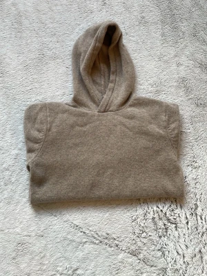 Beige hoodie i mjukt material - Säljer en beige hoodie med klassisk passform. Jag köpte den själv för 900 kr men den är liten på mig! Passar för dig som är mellan 10-16 år! Kan alltid diskutera om priset eller annat! Den är helt ny och inga smuts eller slitage!