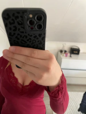 Vinröd spetsdetaljerad topp Bik Bok - Säljer en vinröd långärmad topp från Bik Bok i storlek XS. Toppen har snygga spetsdetaljer vid halsringningen och ärmsluten, vilket ger en feminin touch. Materialet är mjukt och stretchigt för en bekväm passform.