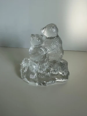 Bergdala Glasbruk - Isbjörnsfigur i glas - Dekorativ isbjörnsfigur från anrika glastillverkaren Bergdala Glasbruk i klart glas som föreställer två isbjörnar stående tillsammans på en isliknande bas. Vacker strukturerad yta. 10x10cm. Ett stycke småländsk konsthistoria i glasform. Mycket gott skick, som ny!