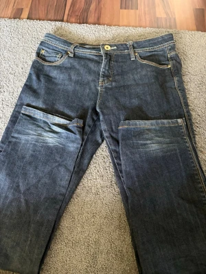 Raka blå jeans  - Säljer ett par blå jeans med raka ben. Jeansen har klassisk femficksdesign, bälteshällor och kontrastsömmar. Materialet är slitstark denim i bomull. Perfekta för dig som gillar en avslappnad och cool stil.
