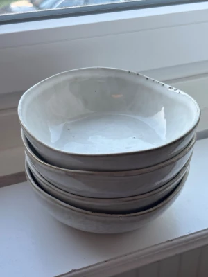 vita keramikskålar - Fyra unika, skålar i vit keramik med oregelbunden form och glansig finish. Perfekta för frukost, snacks eller soppa. Stilrena och enkla att matcha med annan servis.