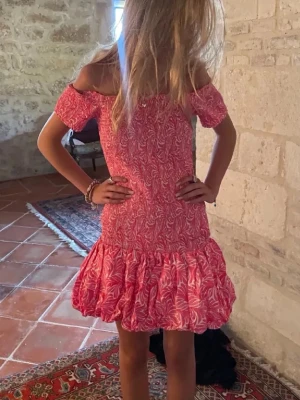 Rosa offshoulder kortklänning med volang - Så fin offshoulder klänning med volanger från hm! Väldigt populär, finns inte att köpa längre🩷Storlek S Materialet är stretchigt och formar kroppen! Skicket är precis som nytt