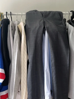 Grå kostymbyxor Jack & Jones - Snygga grå kostymbyxor från Jack & Jones Premium i super slim-modell. Byxorna har en stilren look med smal passform och är perfekta för dig som gillar en modern och dressad stil. Materialet är tunt och följsamt för en bekväm känsla. Detta är byxorna som hör till kavajen 