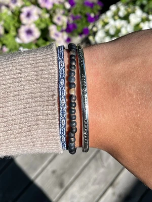 Armband Set - Snyggt armband med tre olika band: ett blåvitt flätat tygband, ett band med små svarta och beige pärlor samt ett silverfärgat metallband med ingraverade mönster. Perfekt för dig som gillar en bohemisk och avslappnad stil. Alla armband är justerbara. Perfekt till sommaren☀️