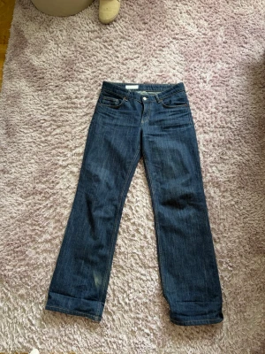 Mörkblå raka jeans - Snygga mörkblå jeans med rak passform och klassisk femficksdesign. Jeansen har normal midja och subtila slitningar framtill. Perfekta till vardags och lätta att matcha med olika stilar. Materialet är denim i bomull. Slitna nere vid fötterna pga för långa