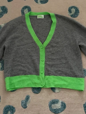 From future kofta - Säljer denna super fina From Future koftan med gröna kanter. Koftan är i bra skick förutom att jag sytt vid armhålan (se bild) inget som syns sedan ett litet hål (se bild) i armen men som inte heller syns. Nypris ca 2000kr. Osäker på storlek men skulle säga S/M